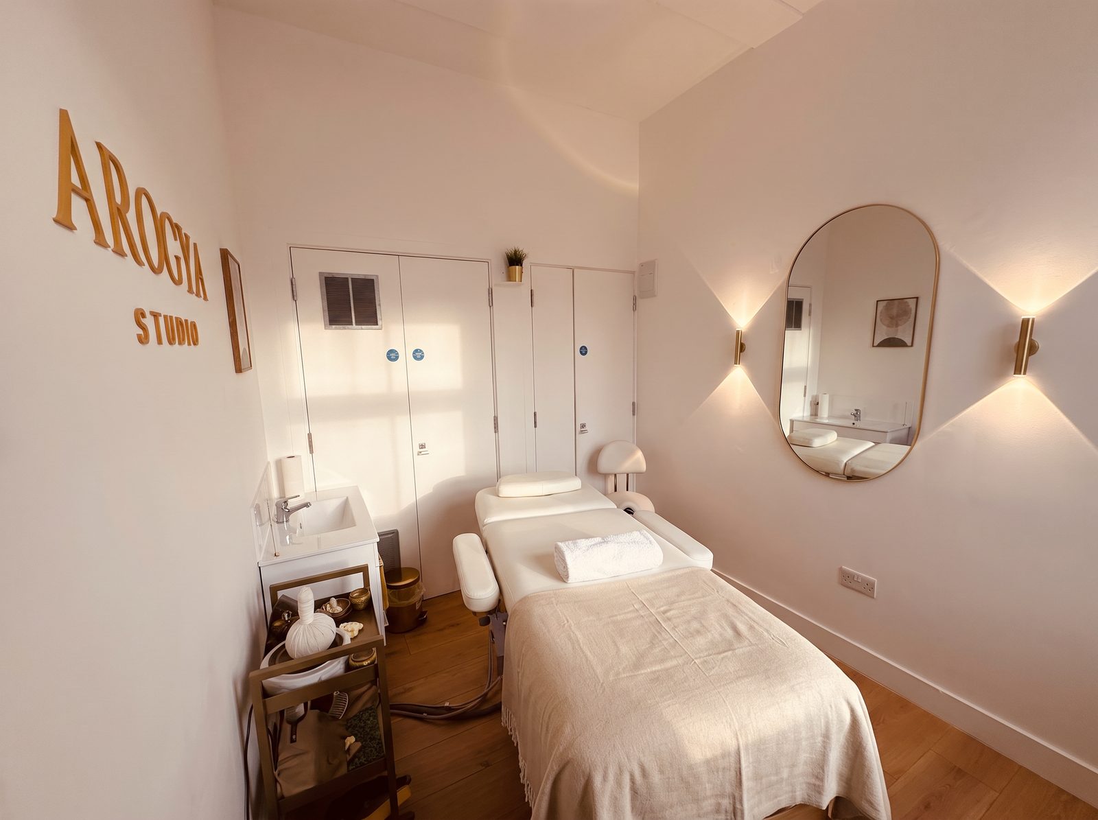 The arched mirror and wall lights in the Arogya Studio treatment room